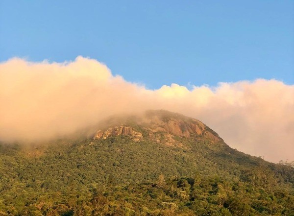 Vista do Morro do Anhangava ao entardecer, com topo parcialmente coberto por nuvens, em Quatro Barras, Paraná